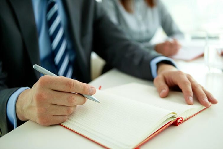 close-up-businessman-with-pen-open-notebook_1098-2741