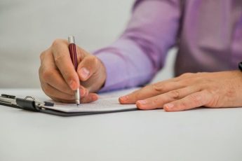 young-man-holding-pencil-writing-paper-diary_1391-167